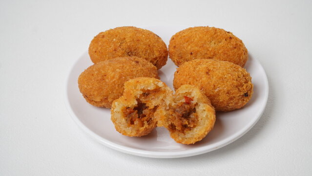 A snack called combro, typical of West Java, Indonesia, made from cassava with oncom chili sauce filling, served on a white plate and placed in a white place (isolated white).