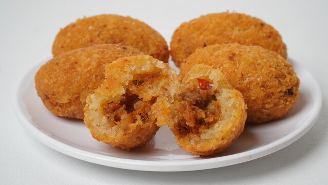 A snack called combro, typical of West Java, Indonesia, made from cassava with oncom chili sauce filling, served on a white plate and placed in a white place (isolated white).