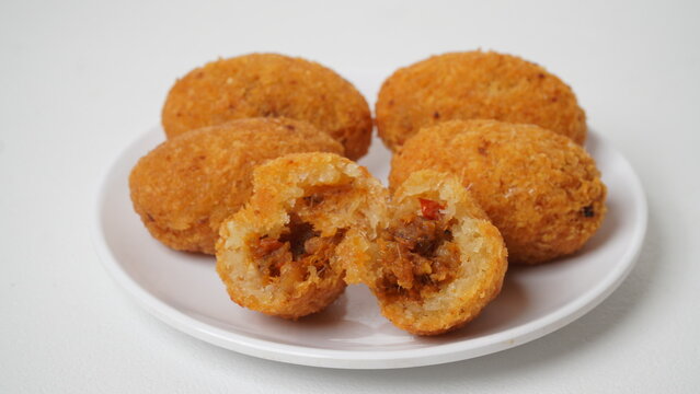 A snack called combro, typical of West Java, Indonesia, made from cassava with oncom chili sauce filling, served on a white plate and placed in a white place (isolated white).