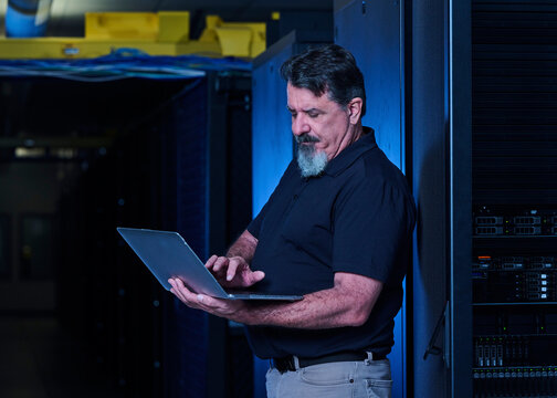 Man using laptop in data center