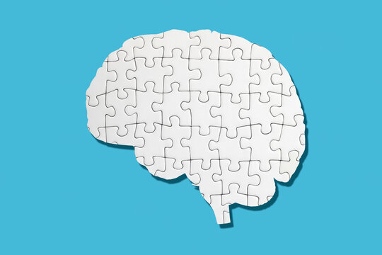 White brain shaped puzzle on blue background