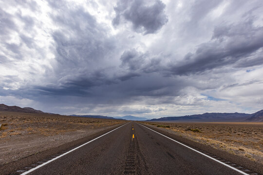 USA, Nevada, Henderson, Storm clouds over empty desert road