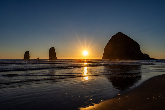 USA, Oregon, Sun setting behind haystack rock on Cannon Beach