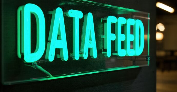 Bright neon sign displays Data Feed. Turquoise glow contrasts dark background. Modern aesthetic, simple message, technology focused.