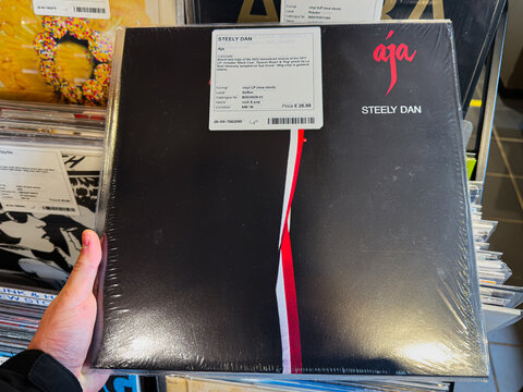 Steely Dan Aja vinyl album cover on display with black cover and red white stripe