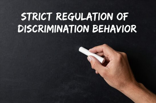 Strict Regulation of Discrimination Behavior Chalkboard Concept Featuring Hand Holding Chalk for Emphasis