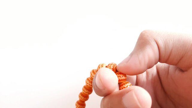 Close-up footage of human fingers counting prayer beads or tasbih during dhikr for Ramadan