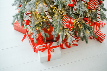 Festive evergreen tree decorated with baubles and lights rests on white wooden planks