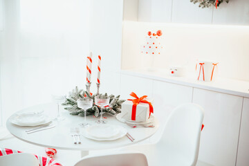 Holiday table setting with festive candles, presents, and sparkling glasses for a celebratory meal