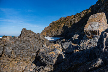 Sandy beach on the Atlantic coast of Portugal with rocks and waves