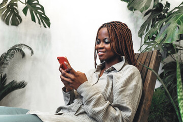 A woman enjoys social media moments in a modern green space filled with an atmosphere of joy.