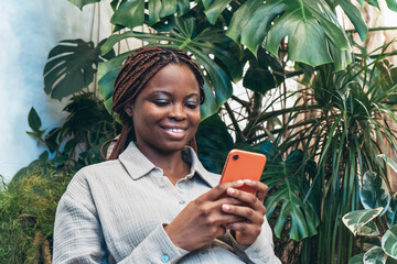 A happy African American woman uses a smartphone