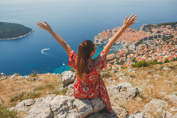 A woman enjoys nature and tranquility from above and admires the stunning view of Dubrovnik