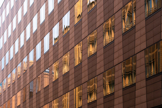 Urban corporate office architecture building facade with window grid in brown tones capturing warm light for modern business district exterior background