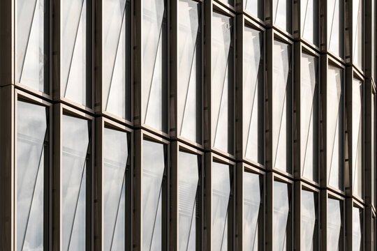 Modern corporate architecture facade with glass window pattern and grid texture creating abstract geometric rhythm for contemporary urban business design
