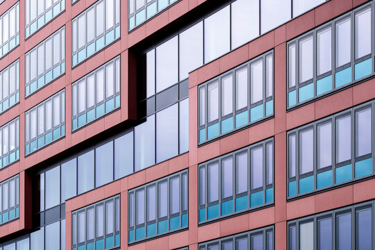 Modern urban office architecture building facade with window color blocks in red and blue creating bold geometric pattern for corporate business design