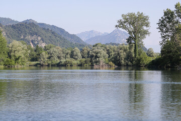 Panoramic view.
Panoramic view of river Adda with water, wood, and mountains at background.
