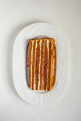 Elegant layered cake slice served on white plate with visible cream and berry filling