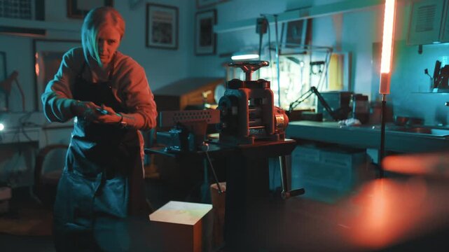 Jeweler craftswoman working metal in her workshop