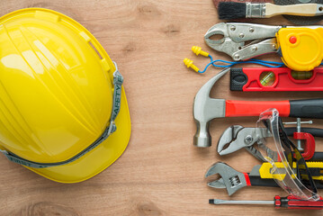 Flat lay work helmet set of construction hardware tools building, repair, improvement, painting accessories on wooden background. Construction industry, repair, maintenance, hardware tools concept.
