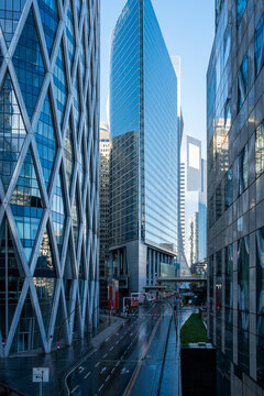 Modern urban street architecture for corporate business finance office towers in Paris La Defense France with glass facades and commuter movement