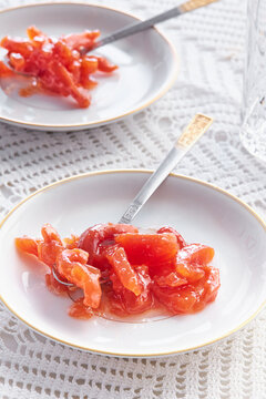 Plates with spoon sweets on a table with a white tablecloth
