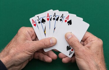 Poker Hand Full House Aces Over Jacks Held By Mature Man Over Green Felt