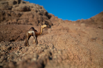 Rzeźba wielbłąda na tle skał i błękitnego nieba – pustynny krajobraz w słoneczny dzień © siwyk