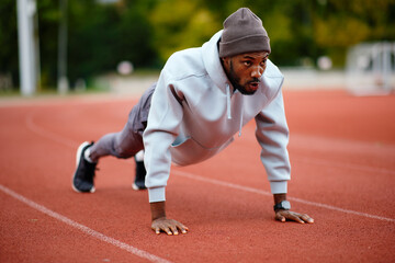 Athlete doing push ups on running track