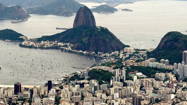 Sweeping aerial perspective of the iconic Sugarloaf Mountain (P&atilde;o de A&ccedil;&uacute;car) and its surrounding urban landscape.