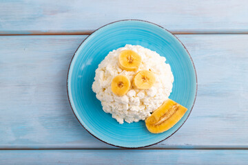 White Сottage cheese, Curd, with Banana on blue wooden, top view, flat lay, close up.