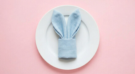 Light blue napkin folded into bunny ears on a white ceramic plate.