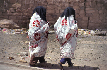 Two women in veils walking together at a street in Sana; Yemen
