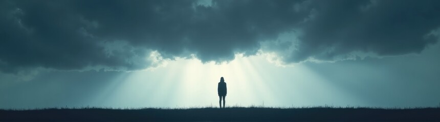 Person standing on a hill under a cloudy sky