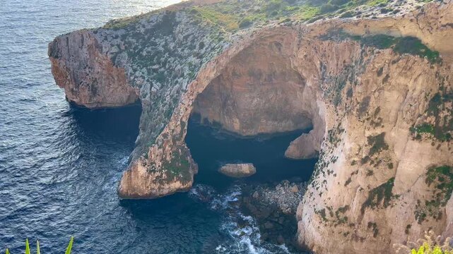 Static view of Blue Grotto sea cave arch in Malta at sunrise.