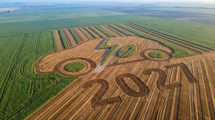 Aerial view of large number 2021 and lightning symbol in farmland