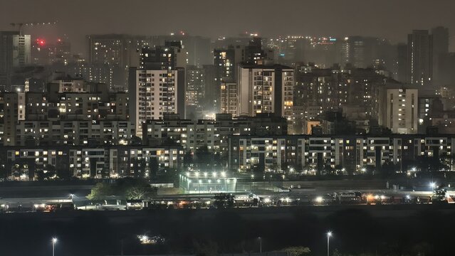 Night skyline of Pune city, India, featuring illuminated residential towers and dense urban living under a hazy sky, showcasing modern growth, city lights, and the vibrant character of a fast-growing 