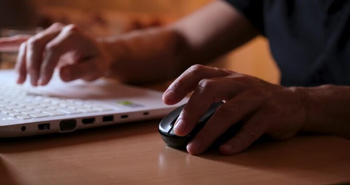Hand Using Mouse While Working on Laptop, Close-Up of Computer Workspace