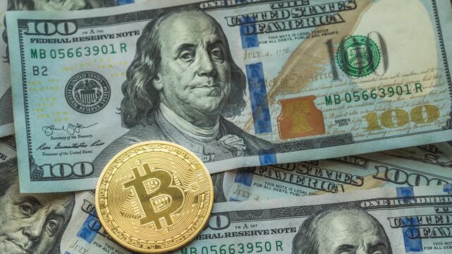 Zoom-in of a golden Bitcoin coin on dollar bills as background