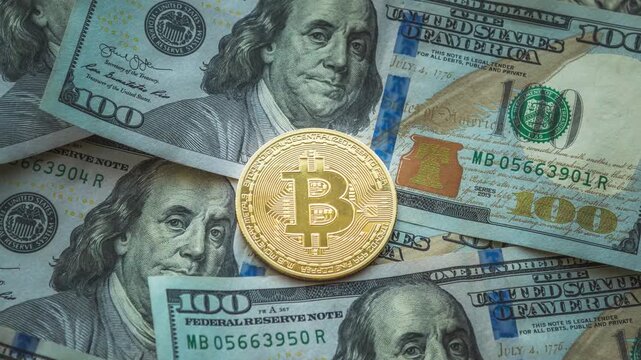 Zoom-in of a golden Bitcoin coin on dollar bills as background