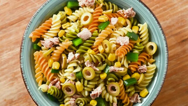 Pasta salad with tuna, corn and olives in bowl. Close up