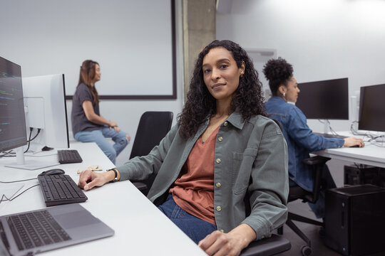 Portrait of a female coder in a modern tech workspace