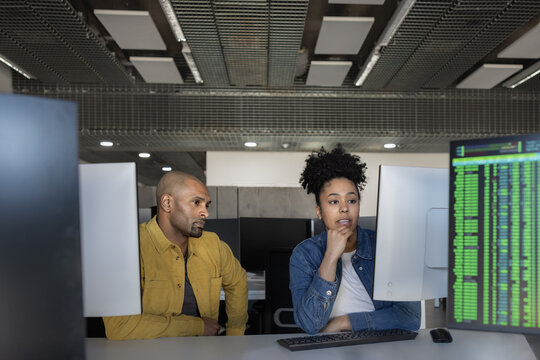 Two individuals collaborating in a modern tech office