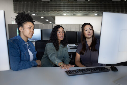 Focused women discussing projects in an office space