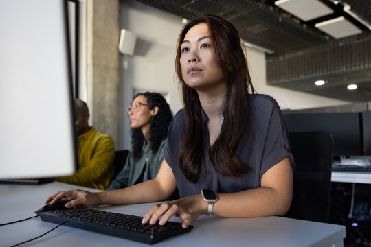 Focused woman working on a computer in a modern office
