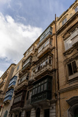 Fototapeta premium Facades of old buildings with windows and colorful balconies on the streets of Valletta, Malta.