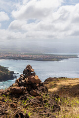 Stone cairn overlooking a calm tropical coastal landscape