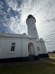 Historic White Lighthouse Against Dramatic Sky