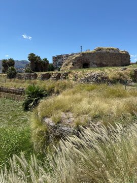 Grassy Ruins and Open Landscape Under Blue Sky in Sicily