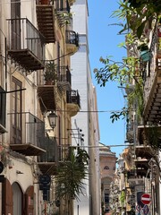 Narrow Sicilian Street with Balconies and Greenery